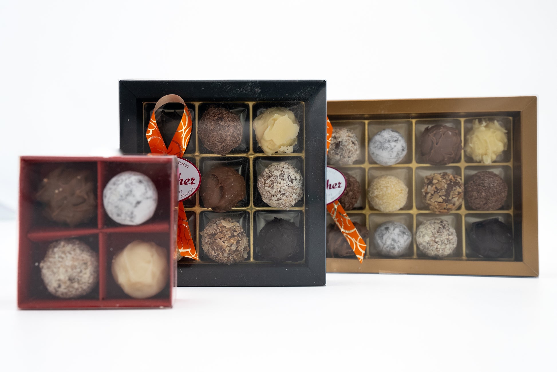 Drei geschlossene Prallinen Schachteln mit handgemachten Sahne-Trüffeln der Bäckerei-Konditorei Streicher