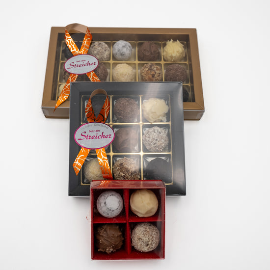 Drei geschlossene Prallinen Schachteln mit handgemachten Sahne-Trüffeln der Bäckerei-Konditorei Streicher