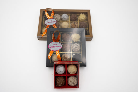 Drei geschlossene Prallinen Schachteln mit handgemachten Sahne-Trüffeln der Bäckerei-Konditorei Streicher