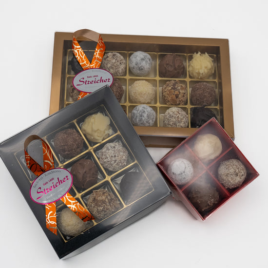 Drei geschlossene Prallinen Schachteln mit handgemachten Sahne-Trüffeln der Bäckerei-Konditorei Streicher