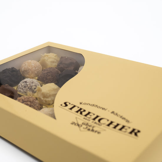 Eine geschlossene 24er-Schachtel mit gemischten, handgemachten Sahne-Trüffeln der Bäckerei-Konditorei Streicher