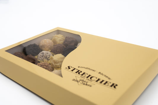 Eine geschlossene 24er-Schachtel mit gemischten, handgemachten Sahne-Trüffeln der Bäckerei-Konditorei Streicher