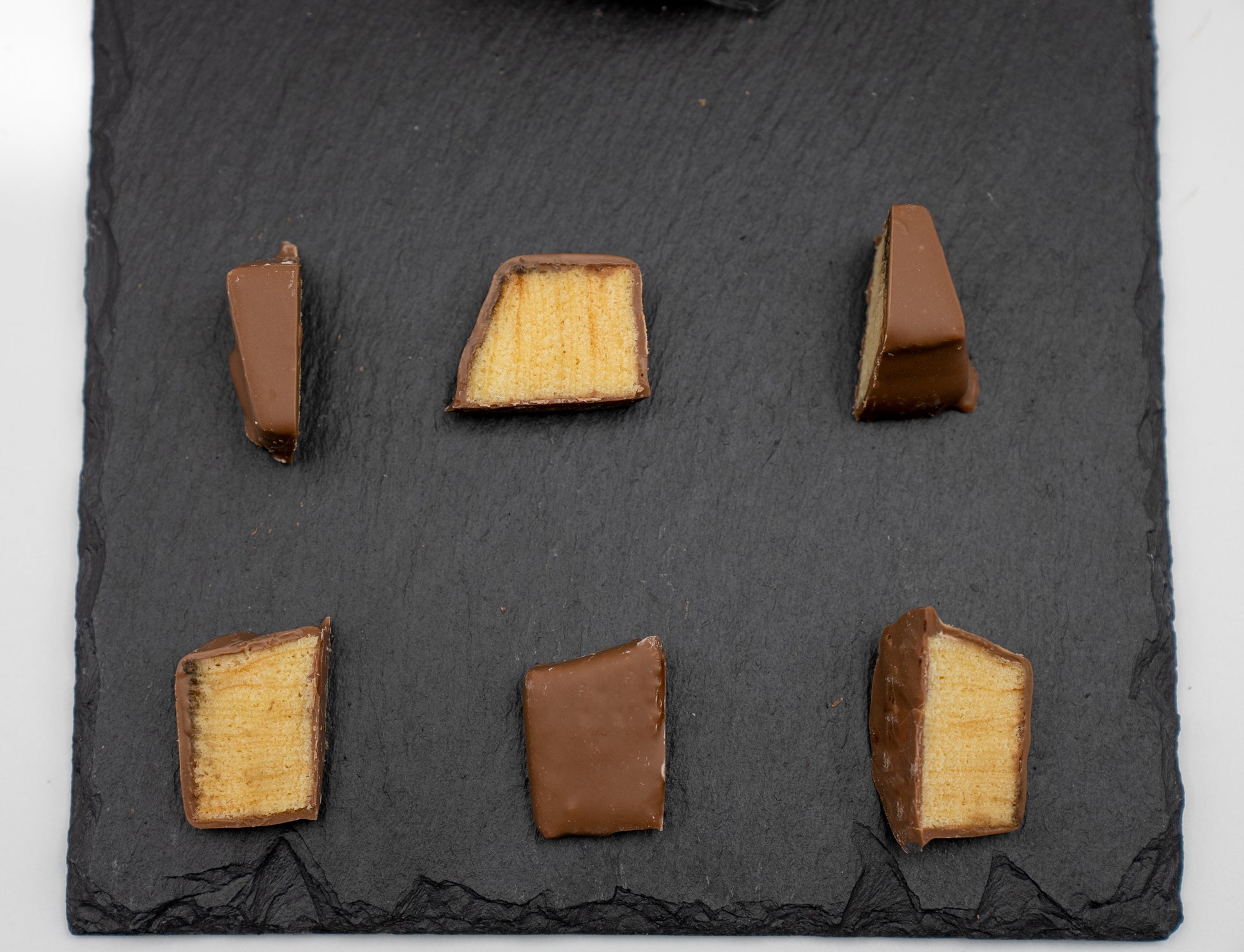 Nahaufnahme von frisch geschnittenen Baumkuchenspitzen mit Zartbitter-Überzug aus traditioneller fränkischer Herstellung